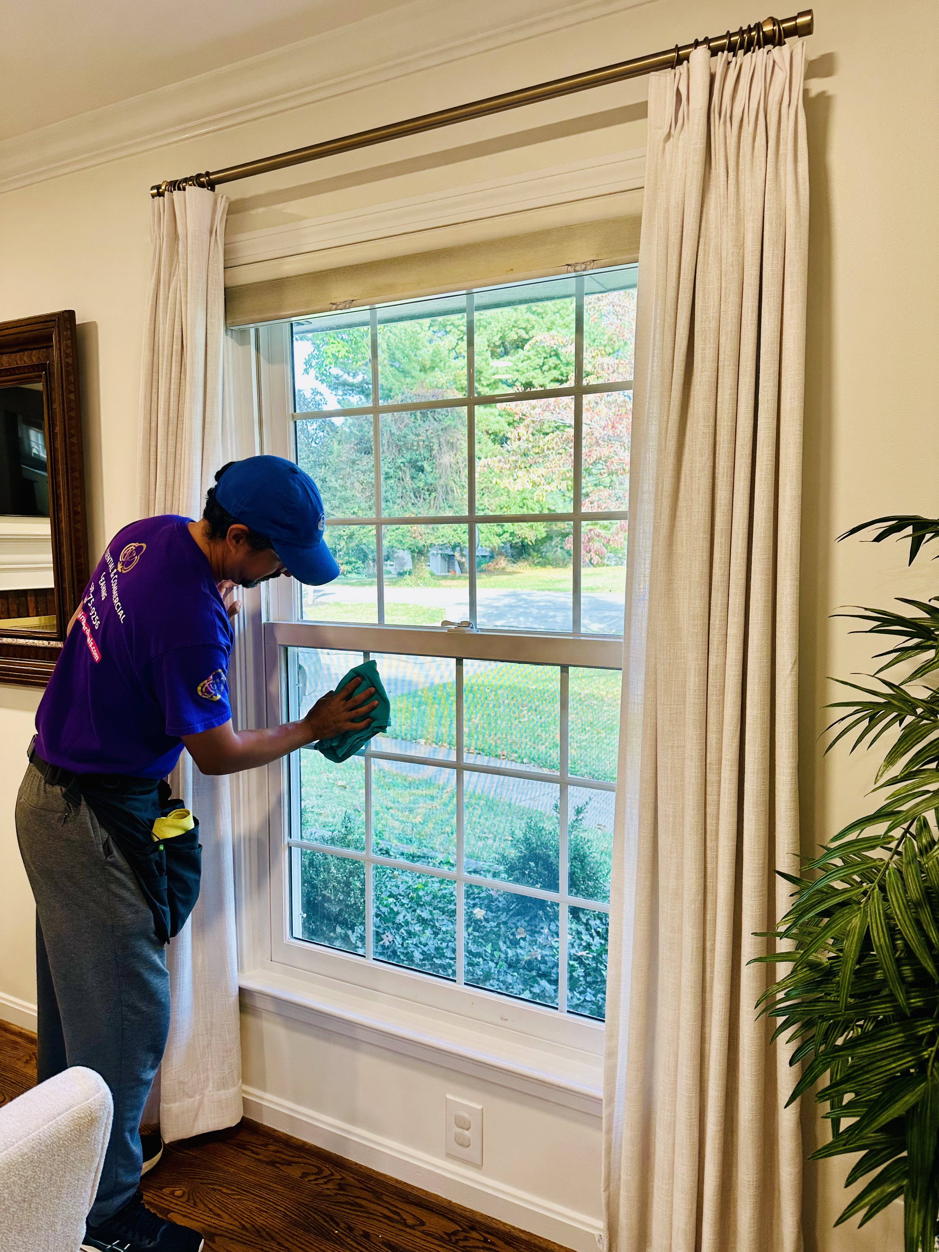 A Cleaning Cardinals team member cleaning the interior of a window