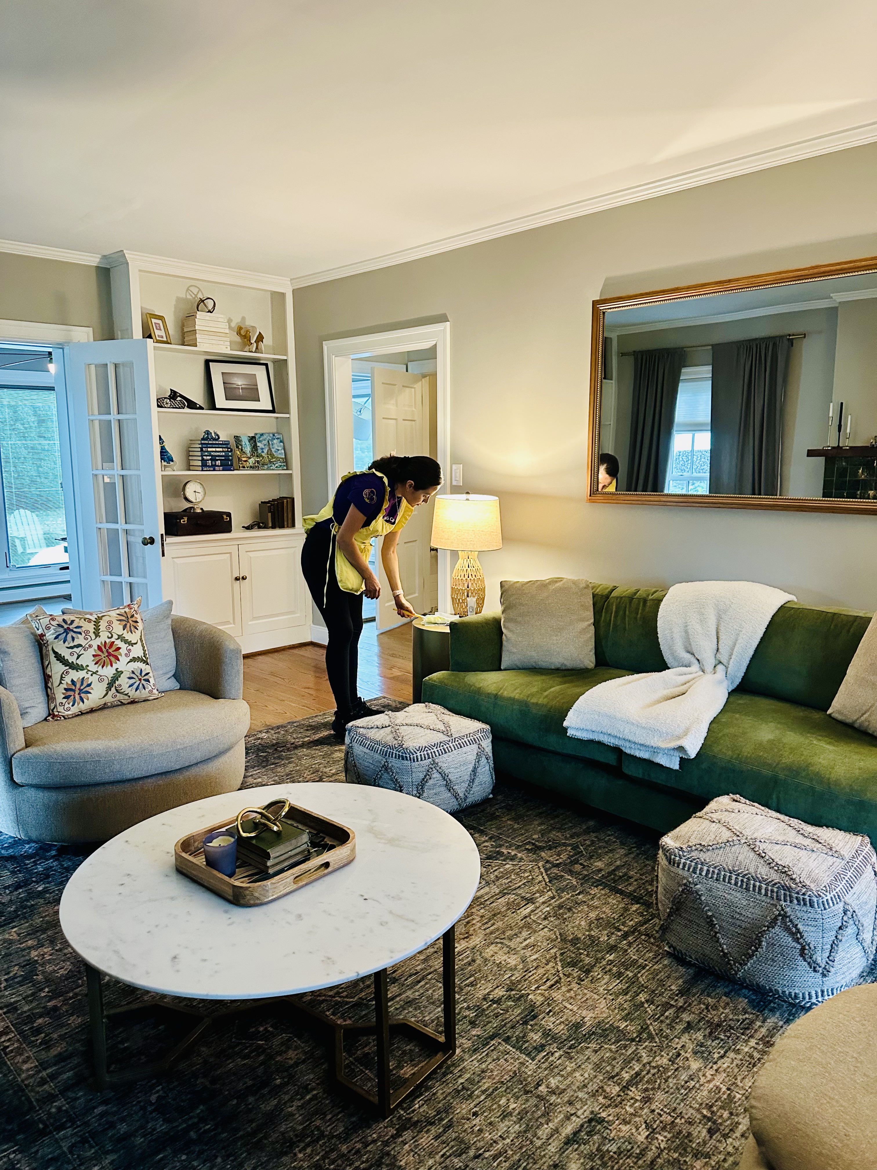 A Cleaning Cardinals team member dusting a living room with care